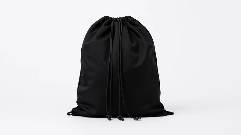 Black drawstring backpack standing upright on white background