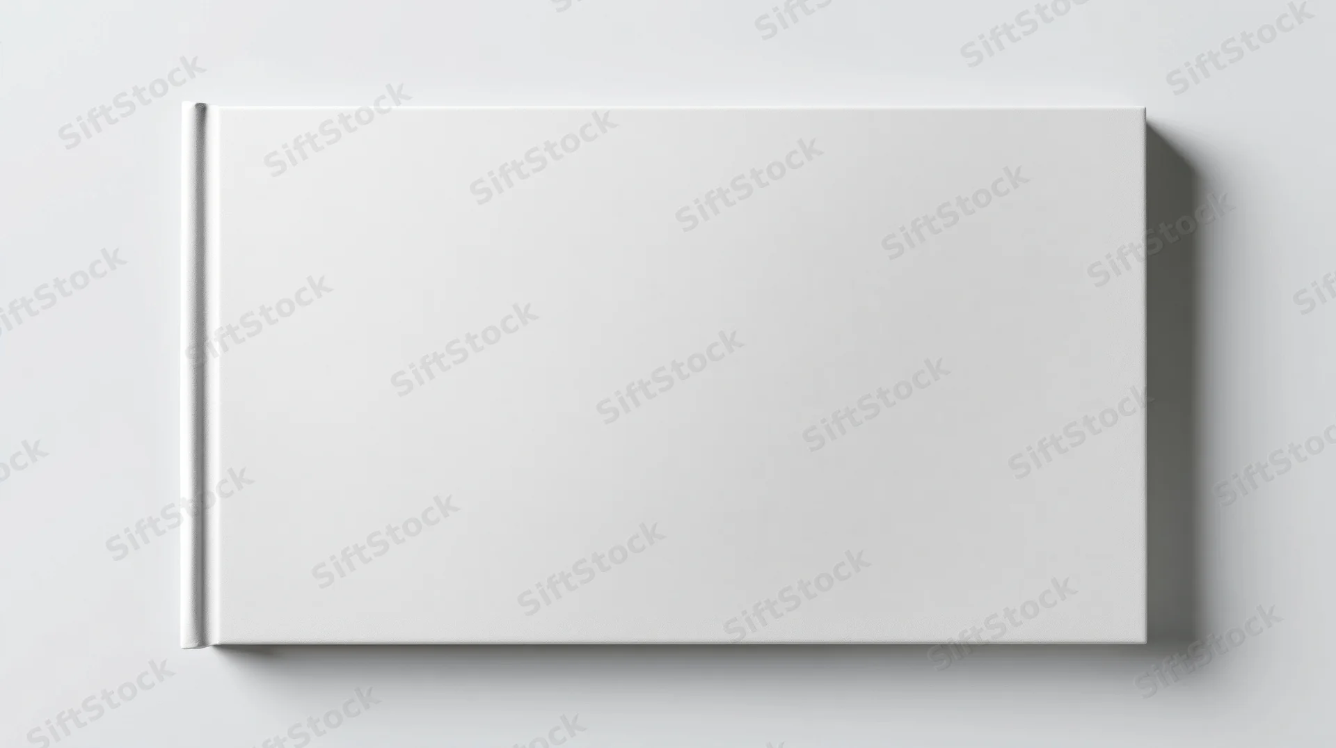 Blank white hardcover book lying flat on a plain surface