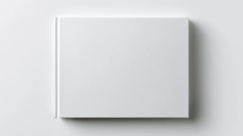 Blank white hardcover book lying flat on a white surface viewed from directly above