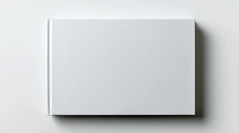 Blank white hardcover book lying flat on a white surface viewed from directly above