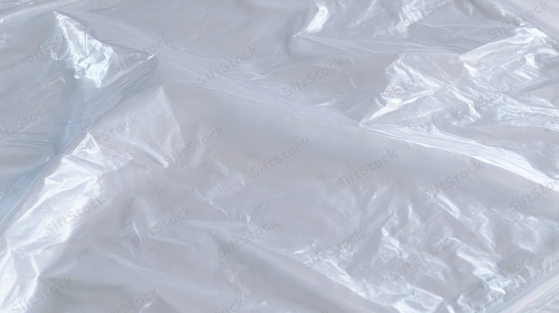Crumpled transparent plastic film on white surface