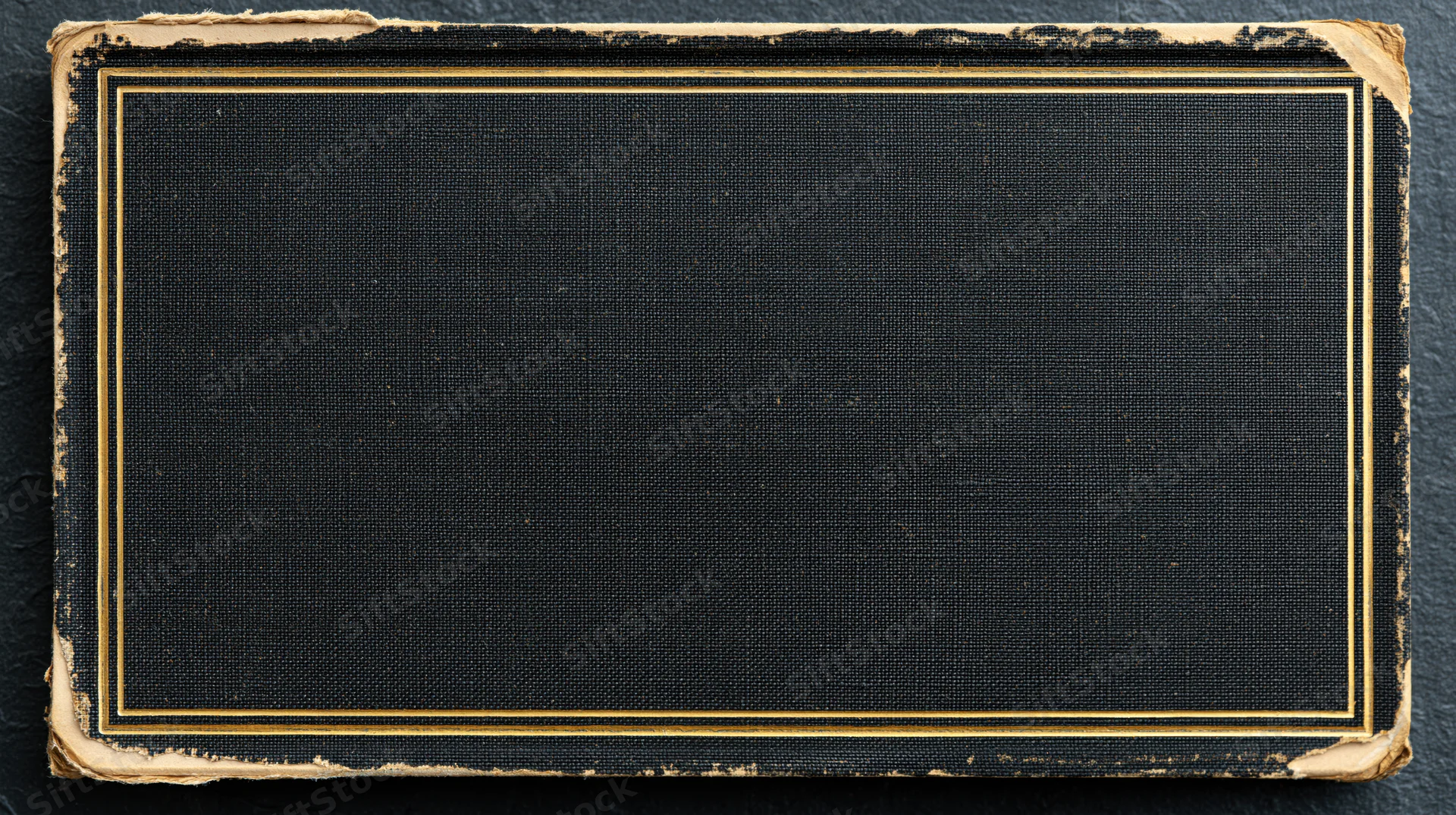 Antique hardcover book cover with gold border and worn edges on dark surface