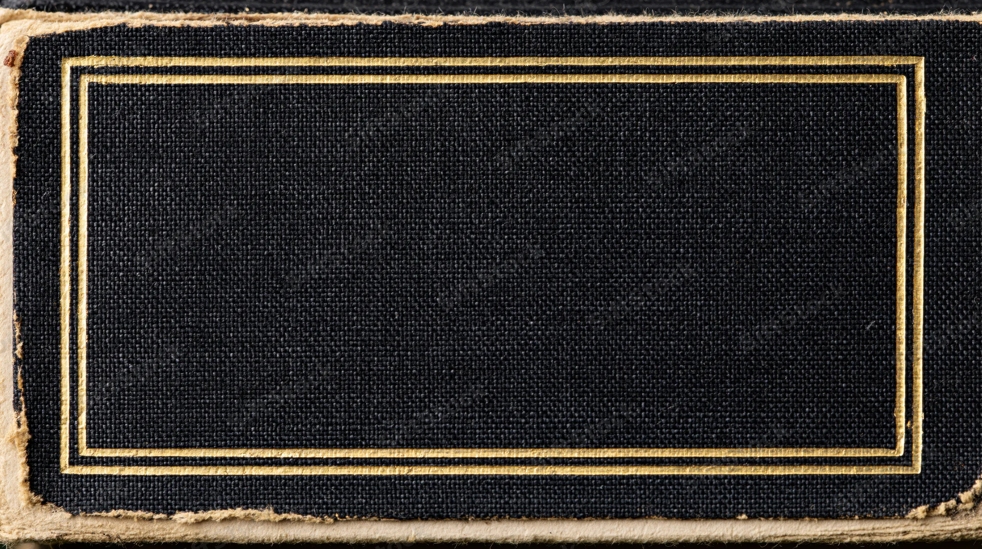 Close-up of an antique hardcover book cover with a blank black fabric center framed by a gold border and frayed edges