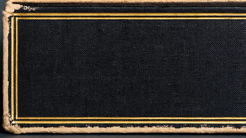 Close-up of an antique hardcover book cover with blank black fabric and gold trim, showing aged edges and texture