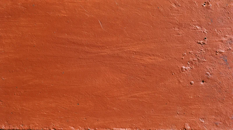 Close-up of a worn reddish-brown painted metal surface with rust and scratches