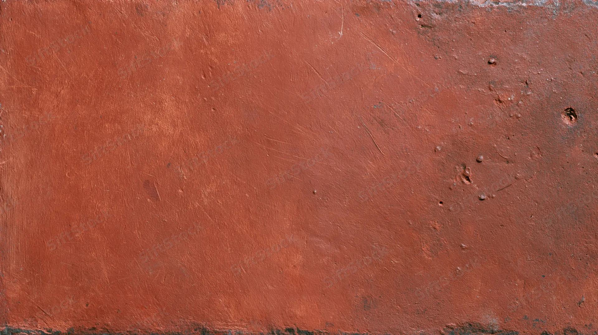 Close-up of a worn reddish-brown painted metal surface showing rust and weathering