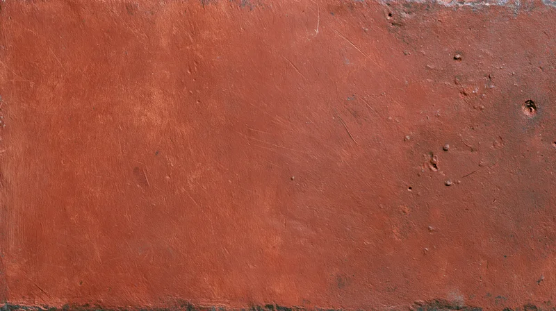 Close-up of a worn reddish-brown painted metal surface showing rust and weathering