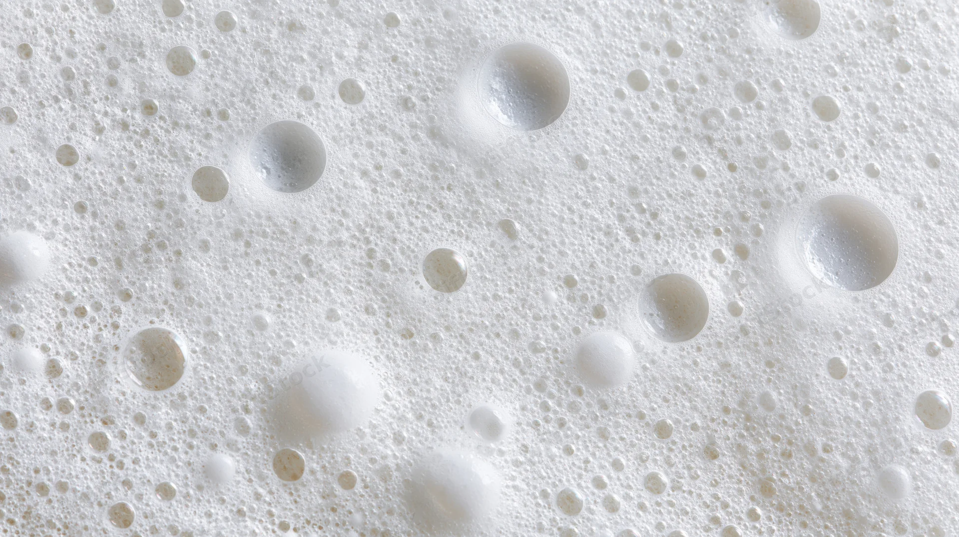 Close-up of white soap foam with bubbles on a smooth surface