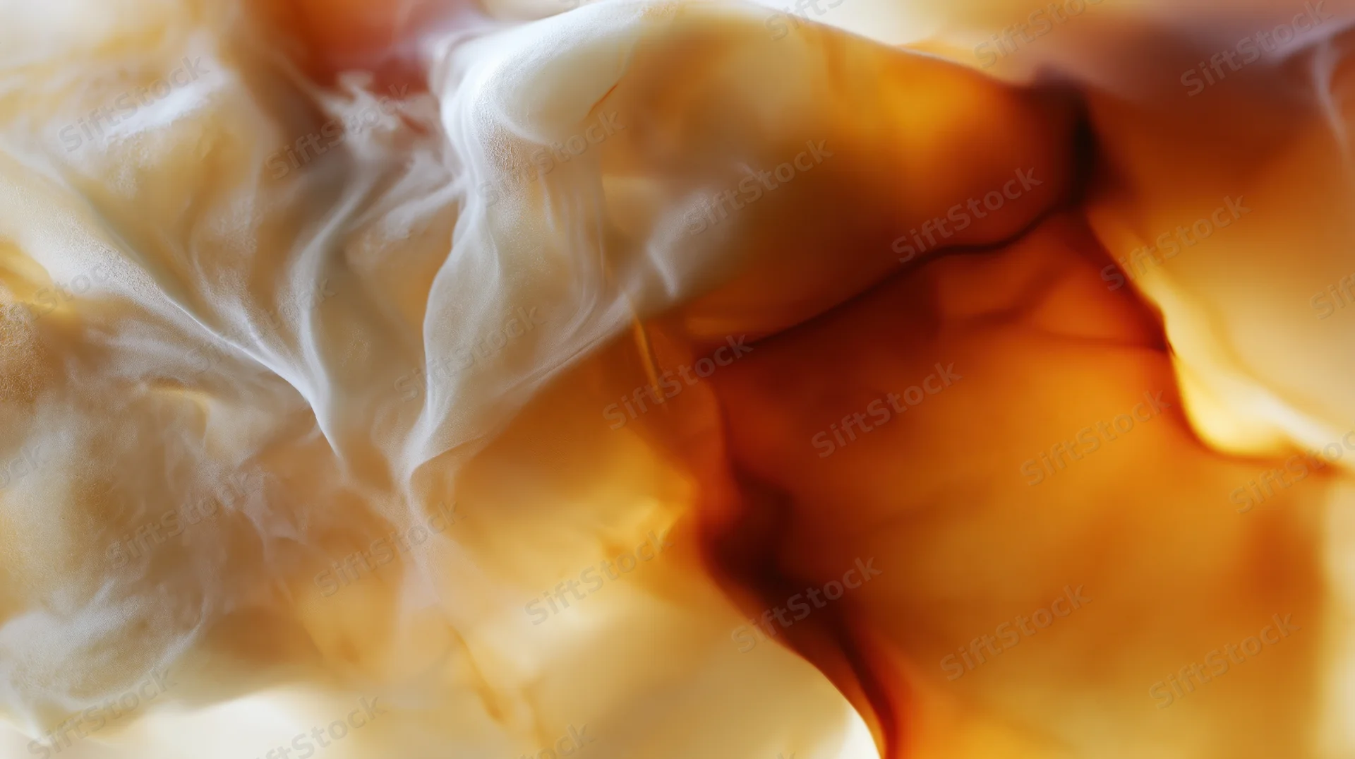 Cream swirling into iced coffee creating abstract fluid patterns