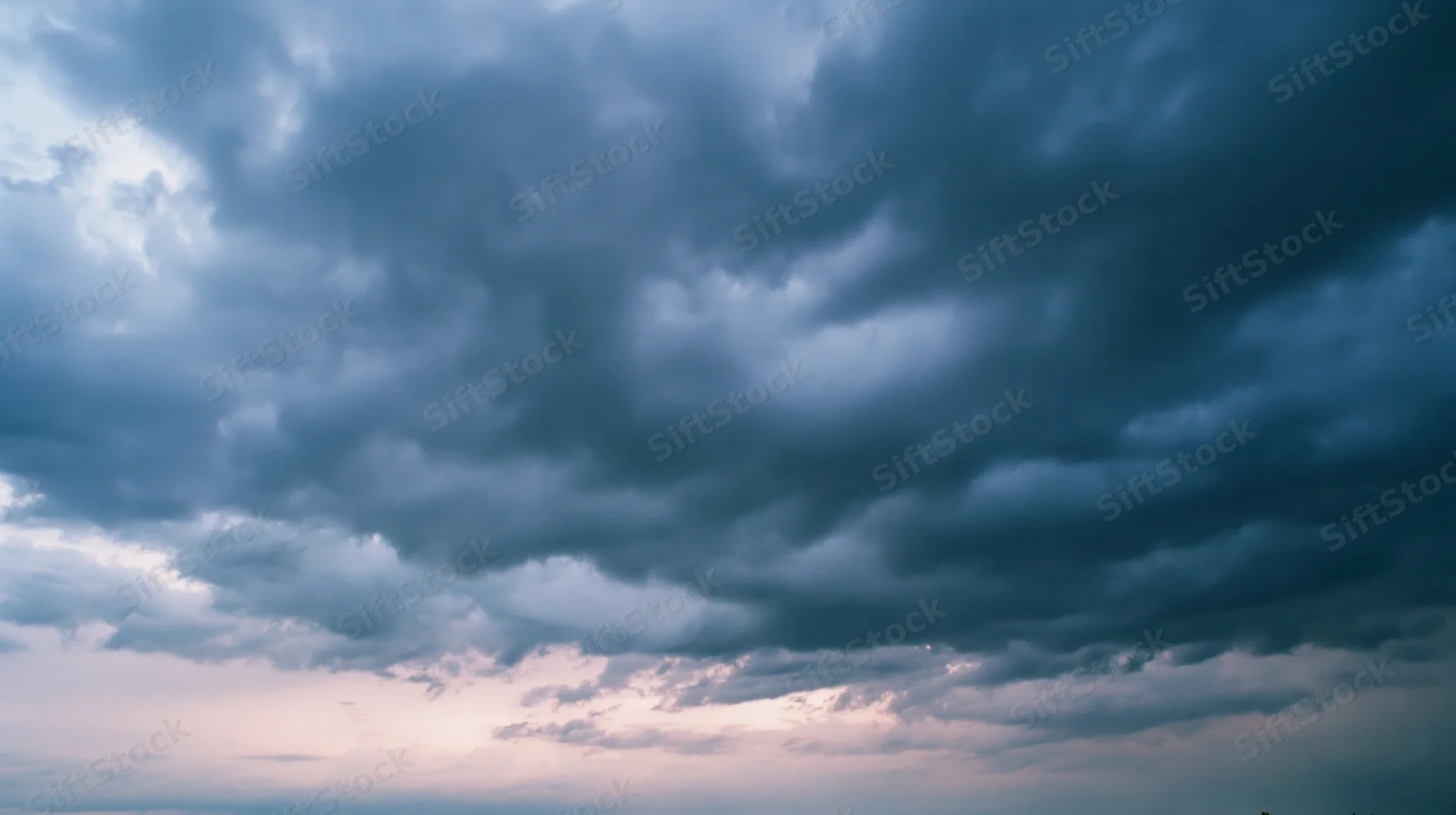 Dramatic stormy sky filled with dark cumulonimbus clouds at twilight