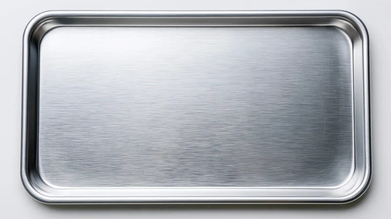 Overhead view of an empty aluminum baking tray on a white surface