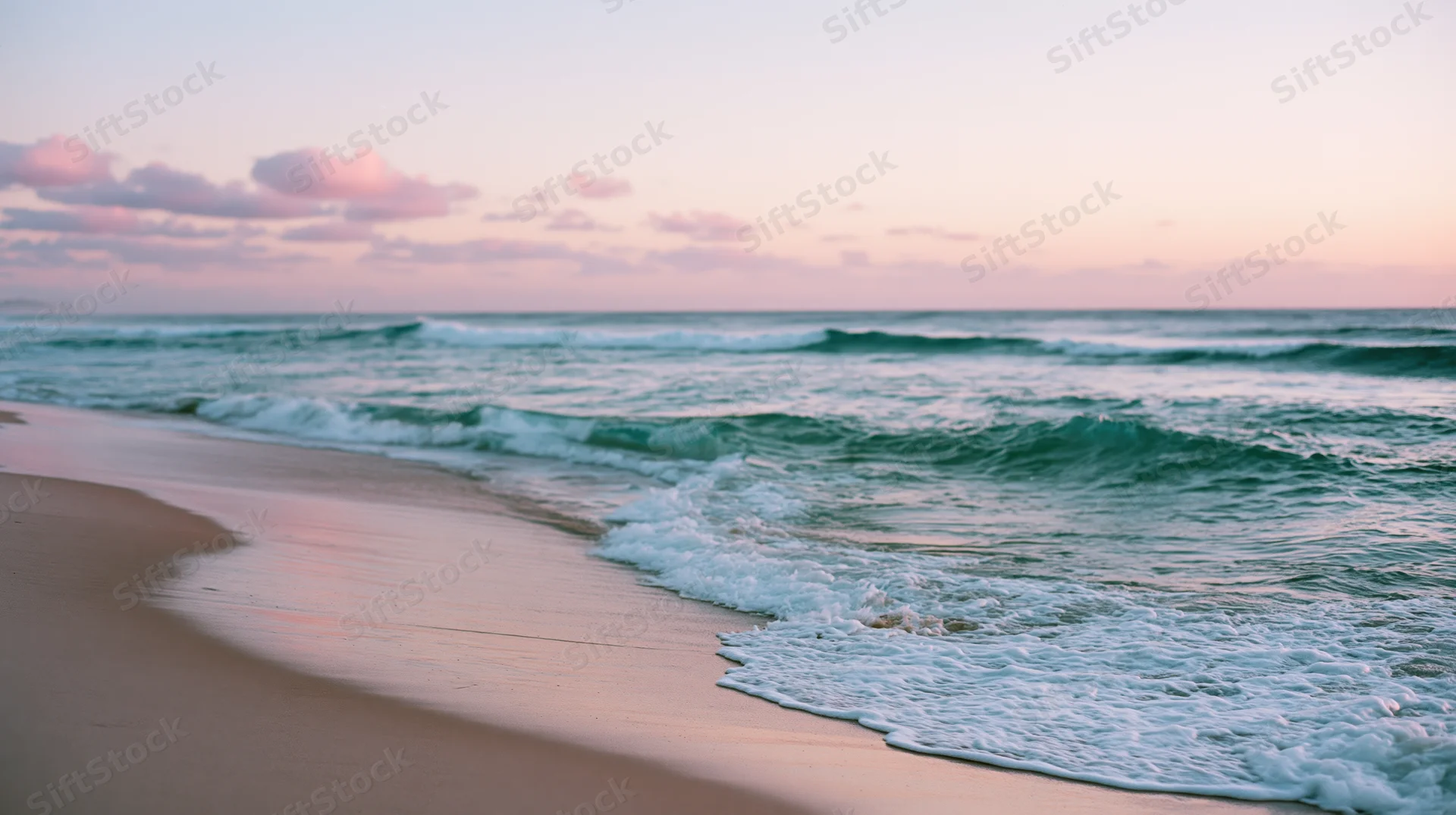 Gentle waves rolling onto a sandy beach at sunset