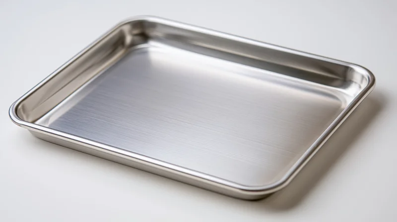 Empty stainless steel baking tray on plain white surface
