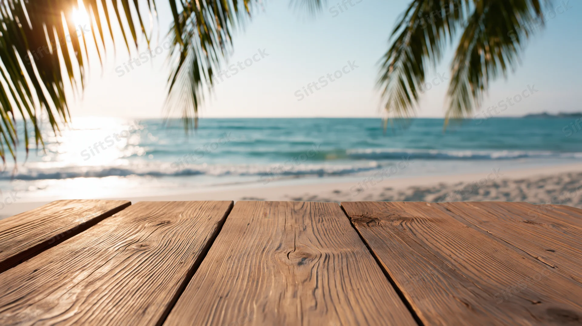 Weathered wooden planks in foreground with tropical beach and ocean beyond