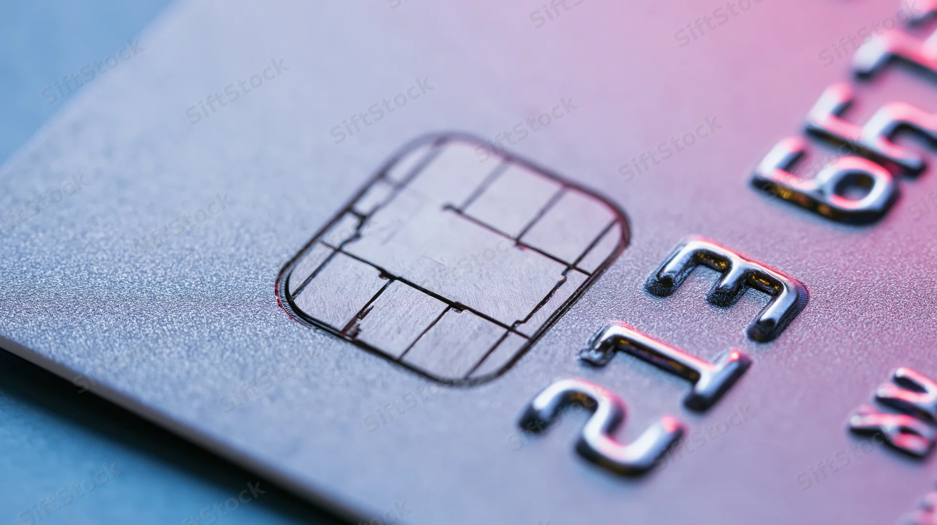 Close-up of a credit card surface showing the embedded chip and embossed numbers