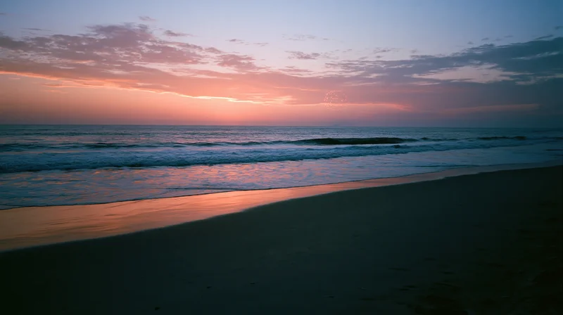 Fireworks bursting over calm ocean horizon at twilight