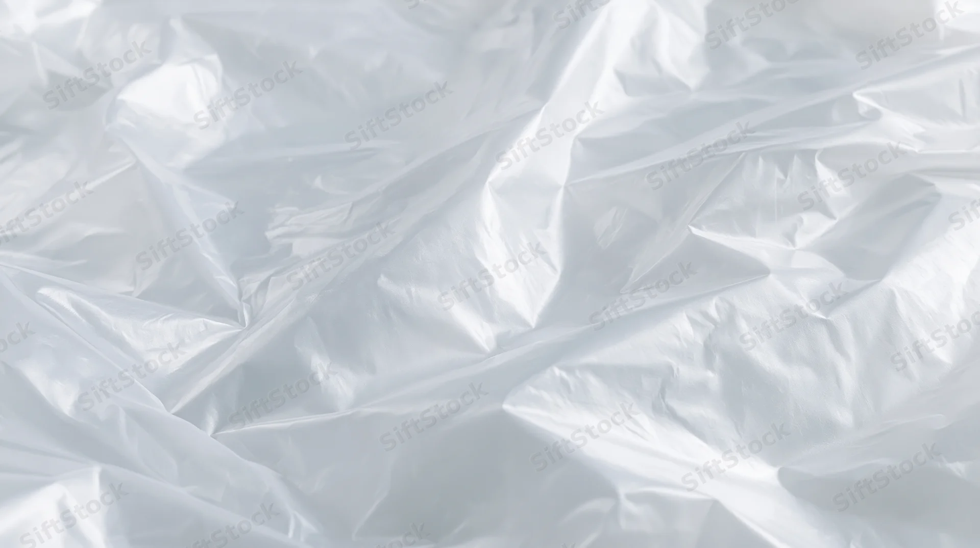 Crumpled clear plastic poly bag surface with folds and creases on white background