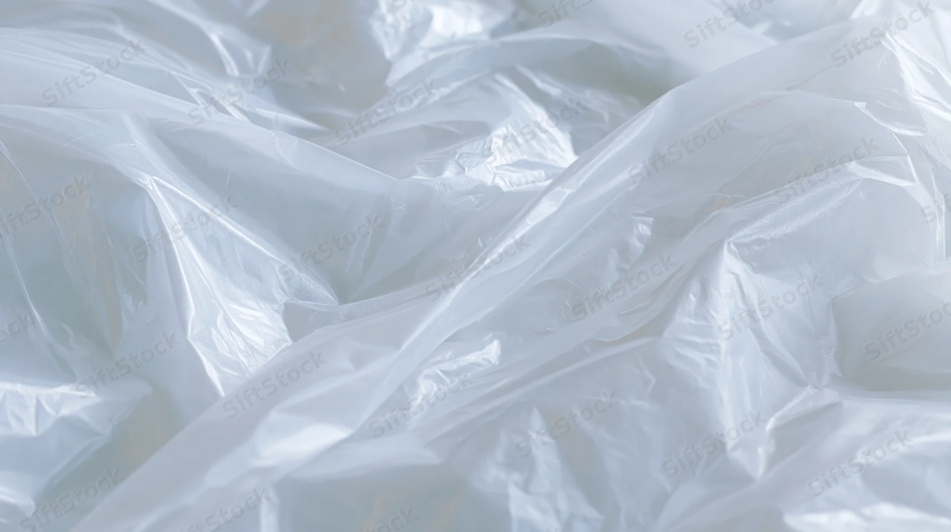 Crumpled clear plastic poly bag lying flat on a white surface