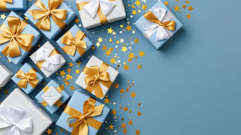 Flat lay of wrapped gift boxes in light blue and white paper with gold ribbons and star confetti on a blue surface