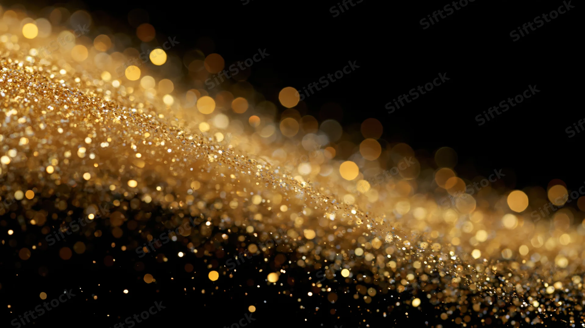 Gold glitter particles drifting in a diagonal wave across black background