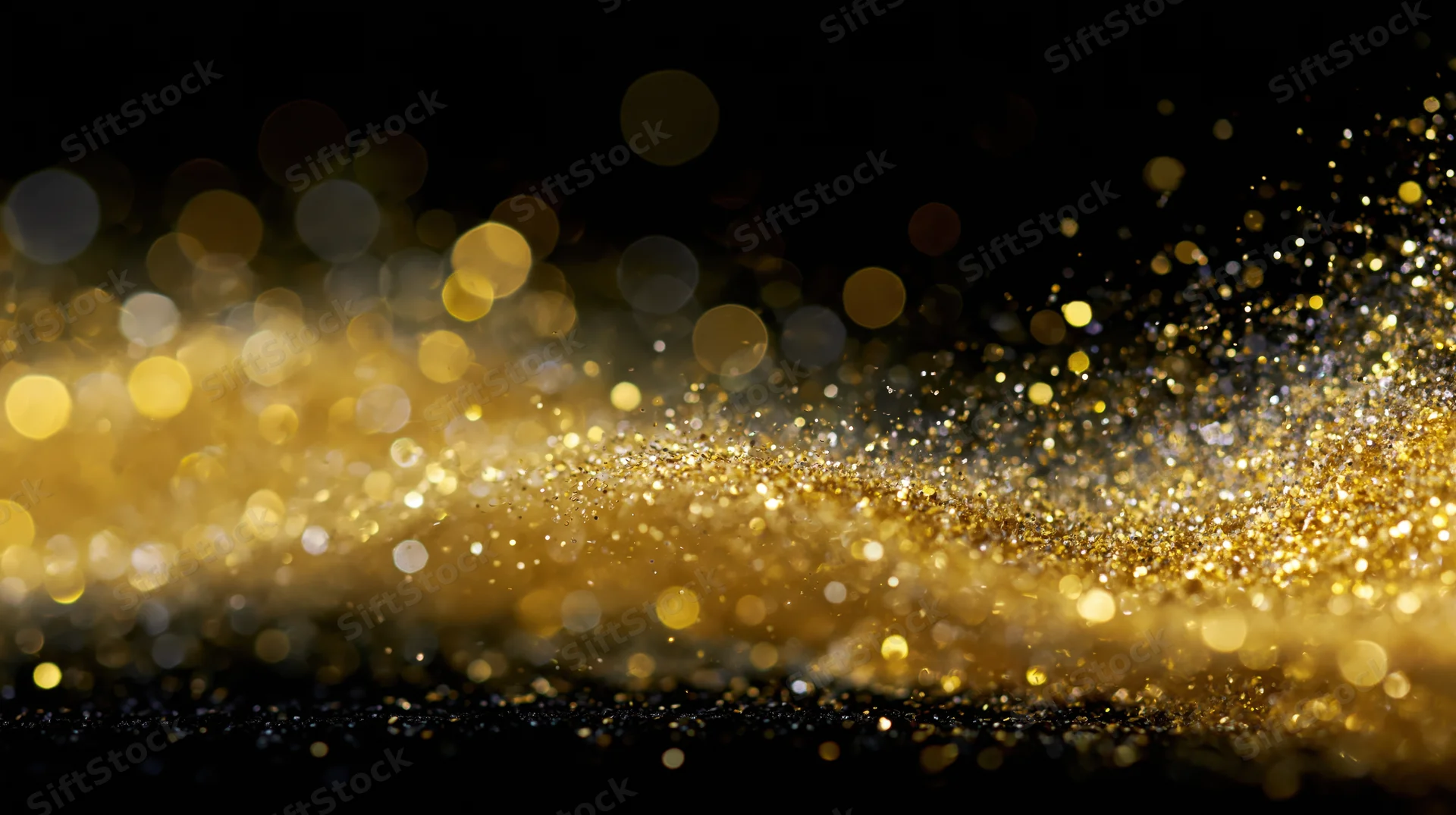 Gold glitter particles drifting in a diagonal wave across a dark background