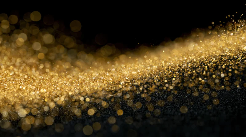 Golden glitter particles drifting in a diagonal wave across a dark background