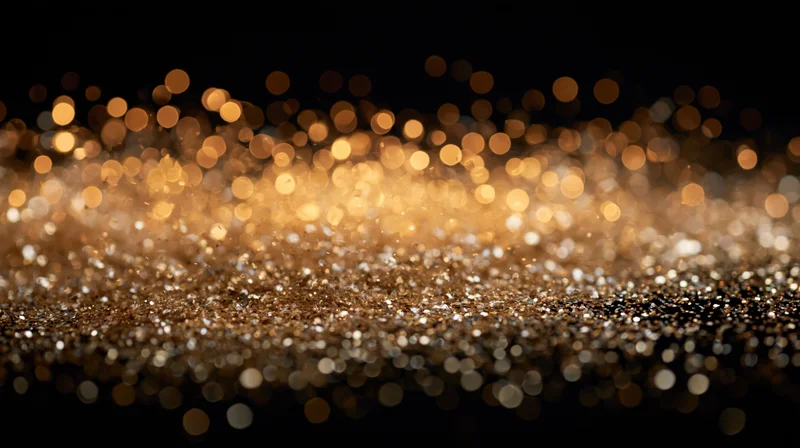 Golden glitter particles falling and scattering against a dark