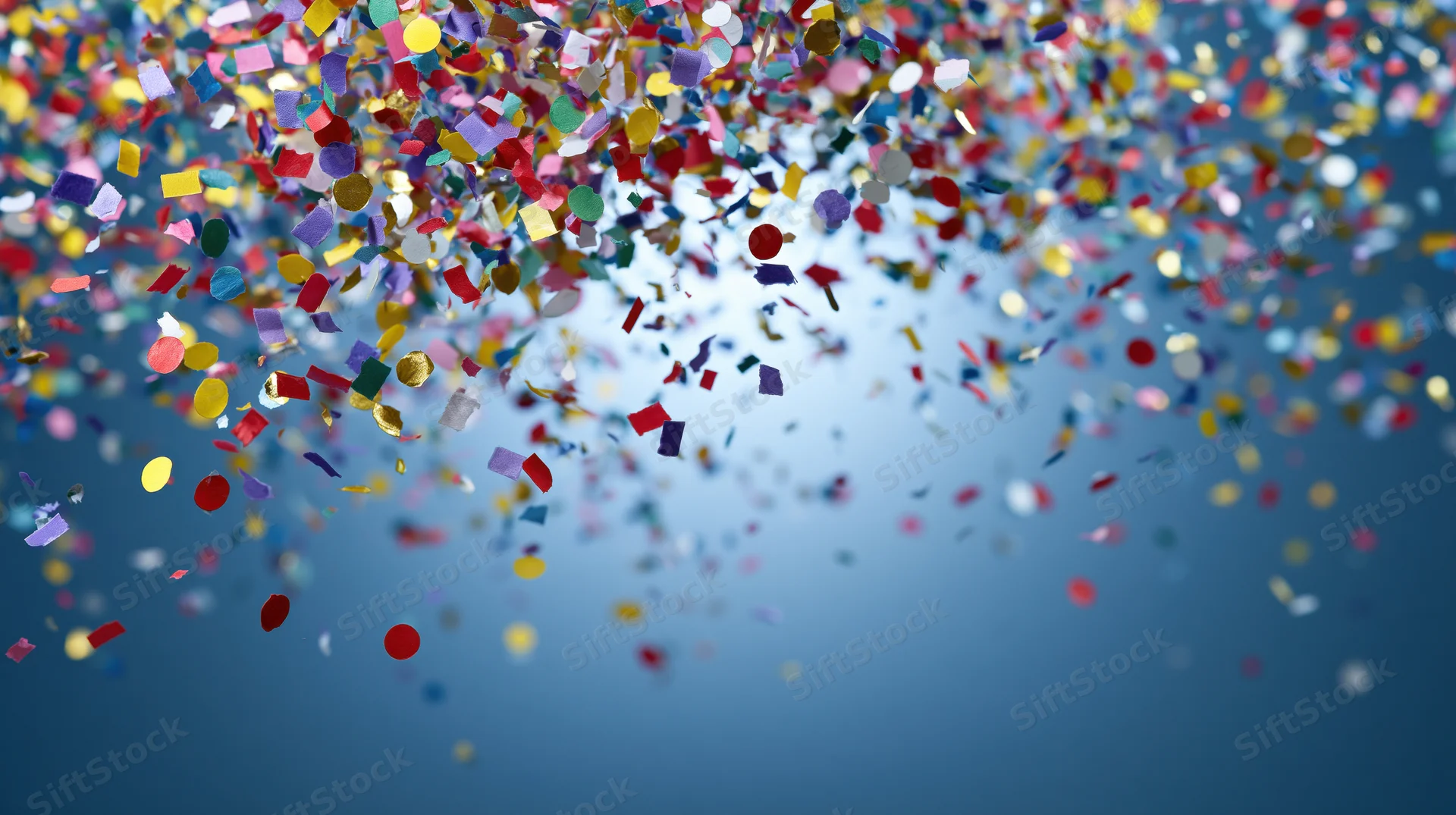 Multicolored paper confetti falling against a blue sky background with copyspace at the bottom