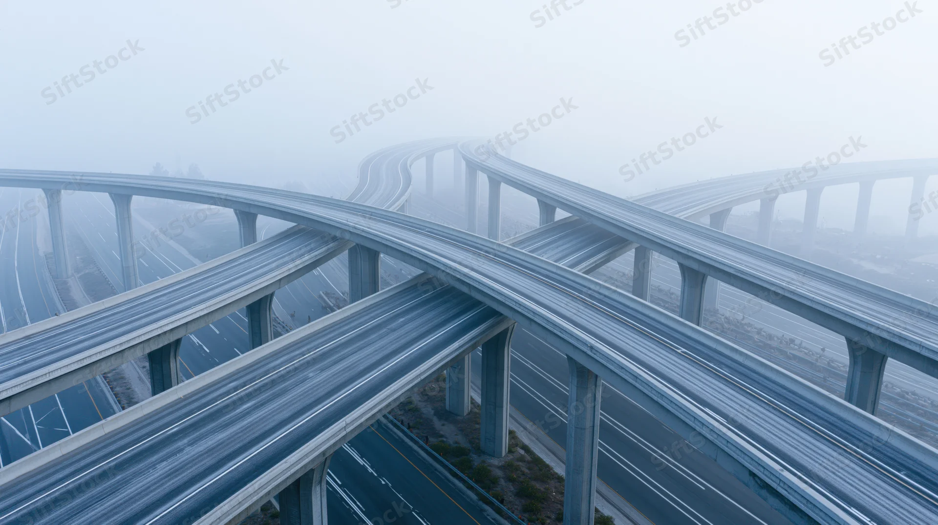 Multi-level highway interchange with stacked overpasses in foggy urban landscape