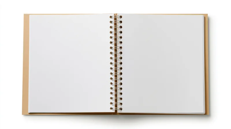 Open spiral-bound notebook with blank white pages lying flat on white background