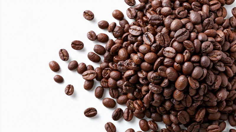Roasted coffee beans scattered and falling midair in a cluster on white background