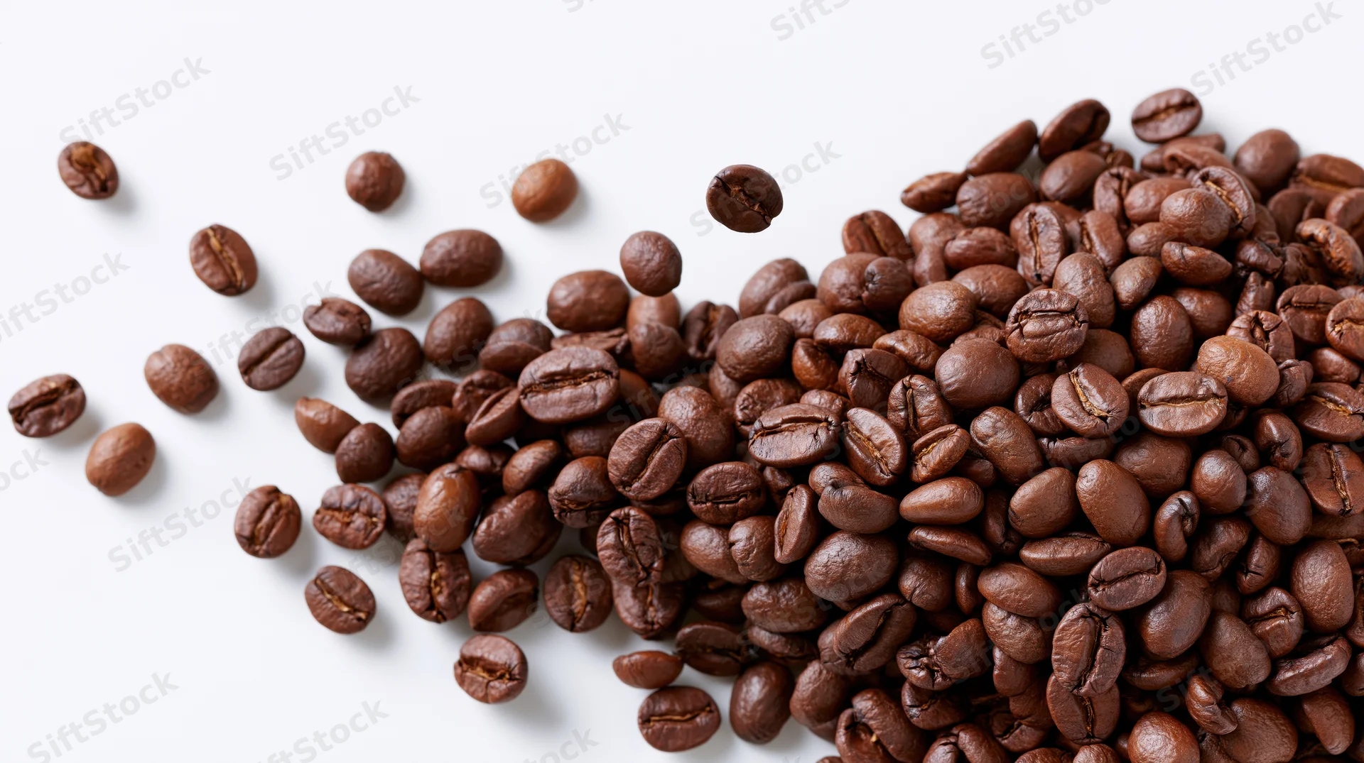 Roasted coffee beans scattered and falling mid-air on white background