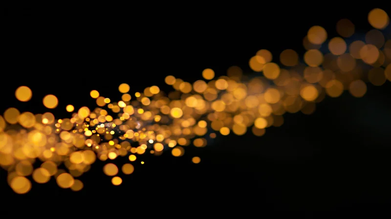 Golden bokeh lights drifting across a dark background with copyspace on the right
