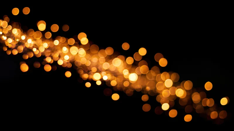 Golden bokeh lights drifting across a dark background