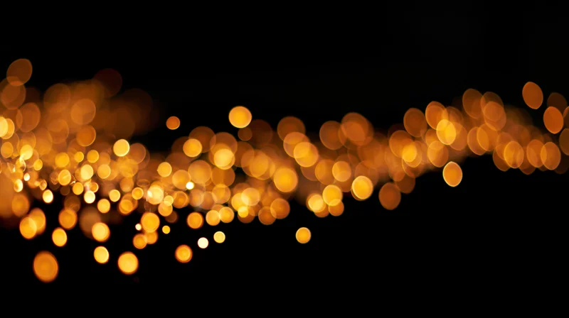 Golden bokeh lights drifting across a dark background