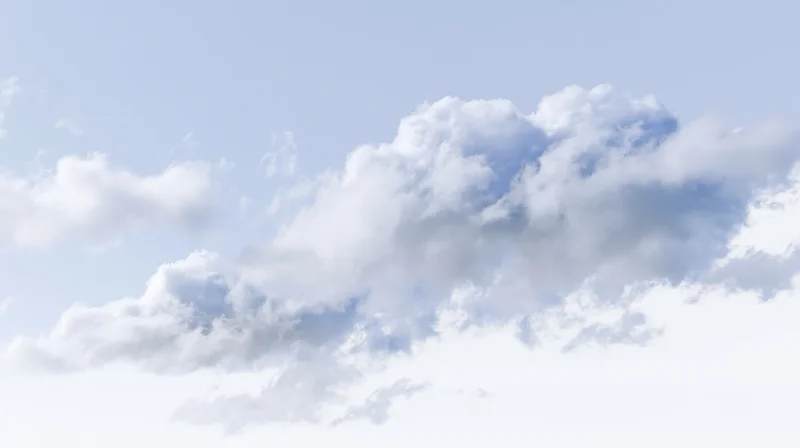 Scattered cumulus clouds drifting across a clear blue sky