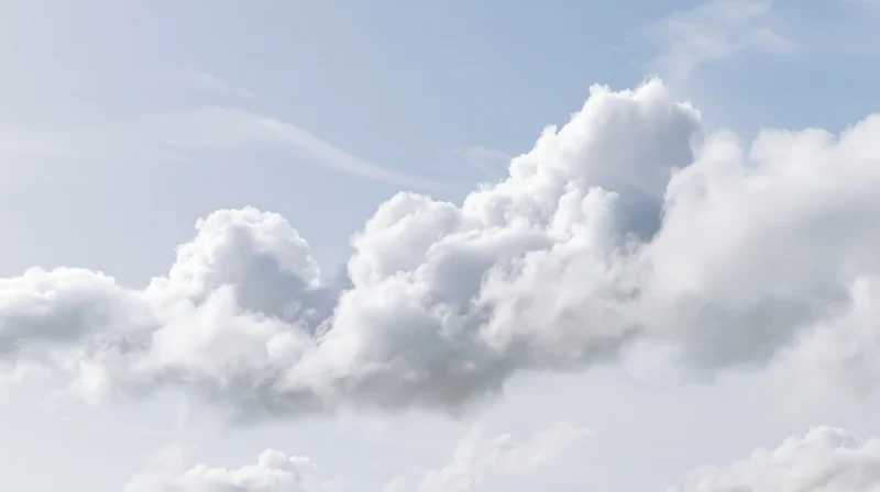 White cumulus clouds drifting across a clear blue sky