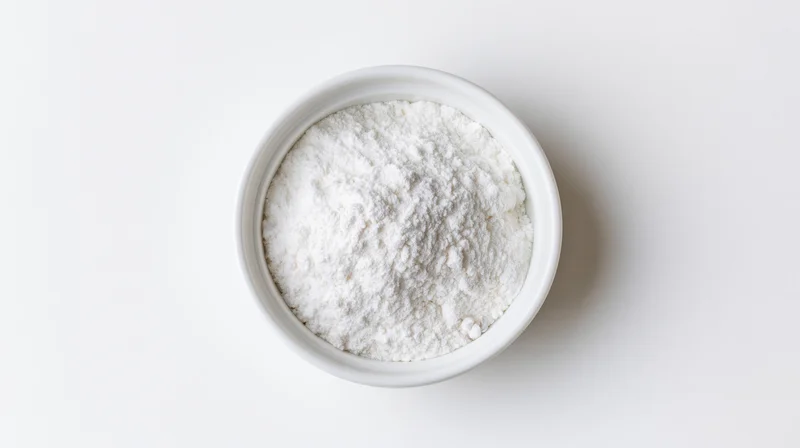 White powder in a small ceramic bowl on a plain white surface