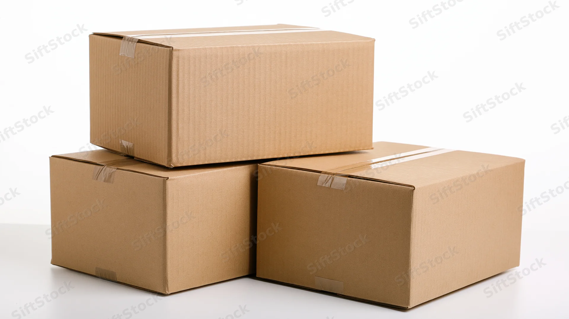 Three sealed cardboard shipping boxes stacked on a white surface