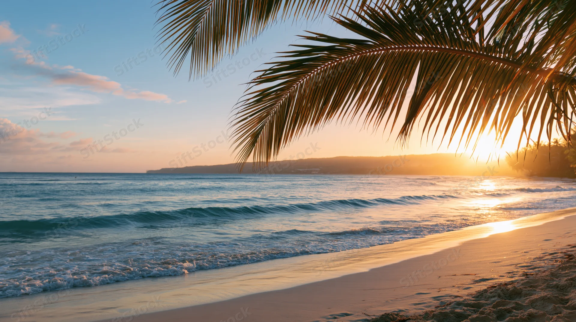 Golden hour sunset over calm turquoise waves washing onto sandy beach under palm fronds