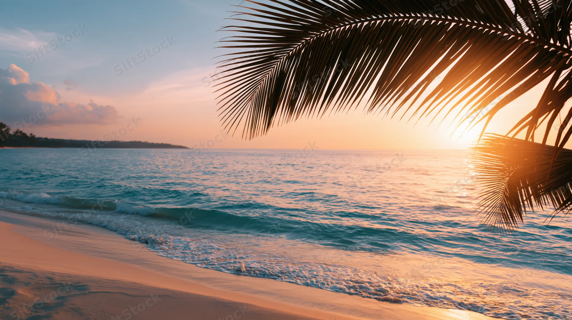 Tropical beach at sunset with palm fronds silhouetted against golden sky and calm turquoise waves washing on sand