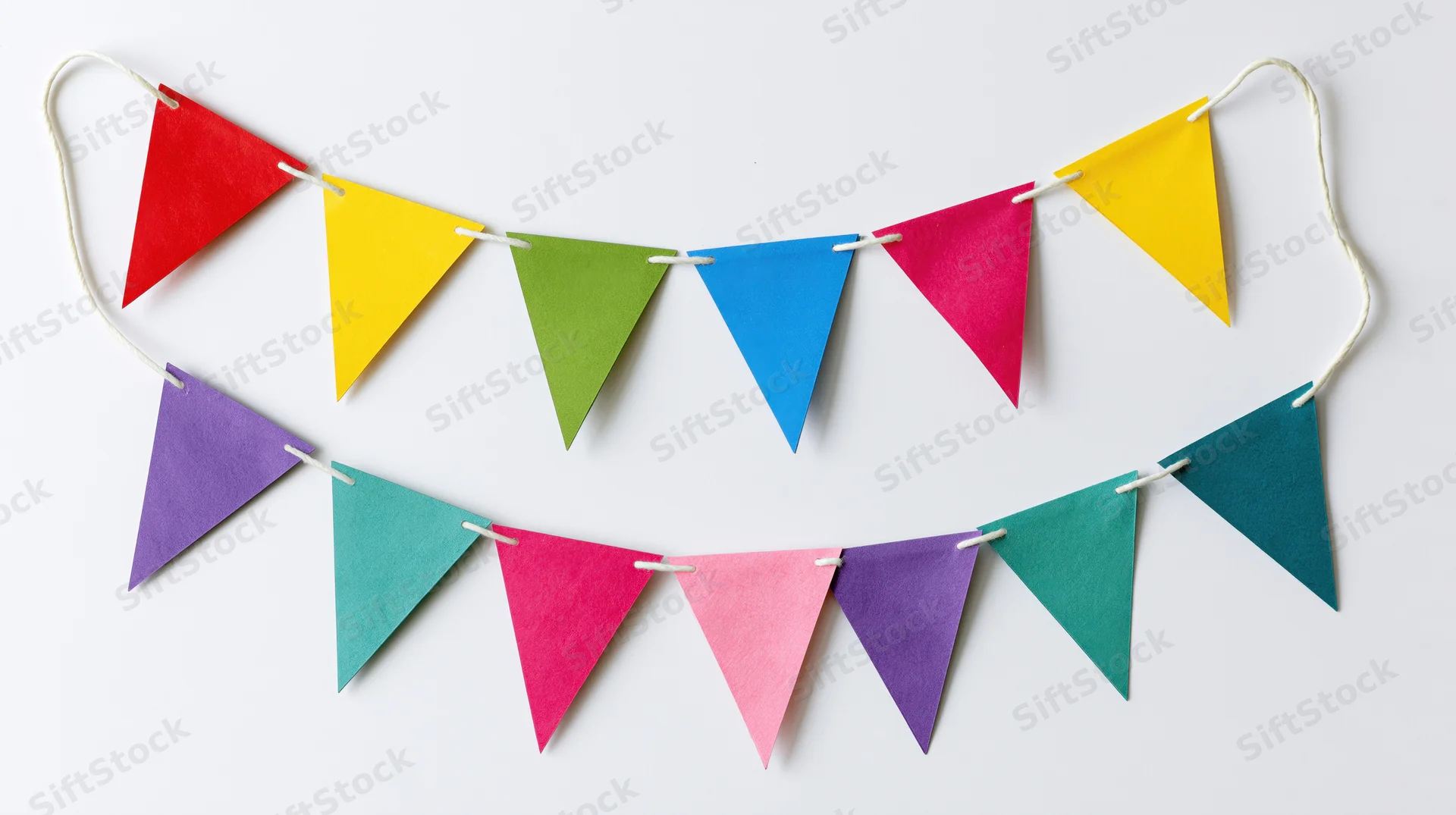 Two strands of colorful triangular paper bunting flags hanging on white string against white background