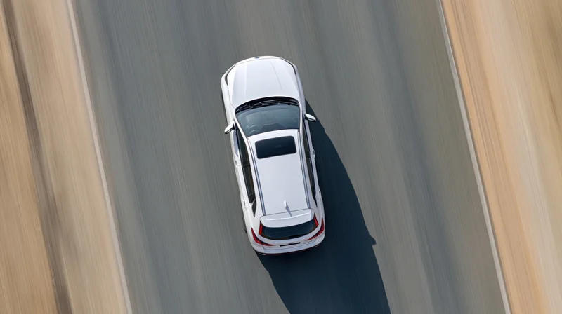 White suv driving at speed on highway viewed from directly above