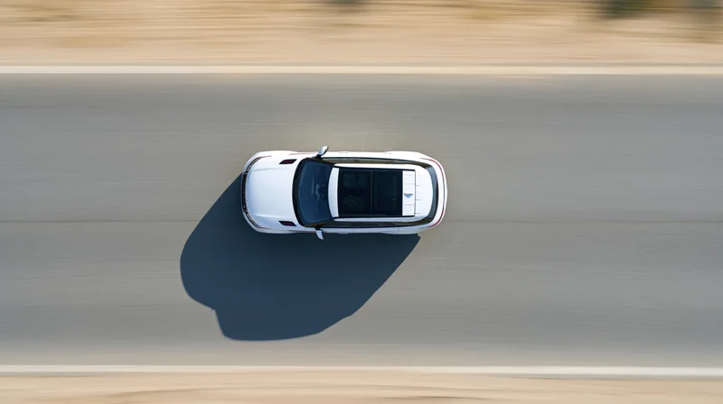 White suv driving at speed on highway viewed from directly above