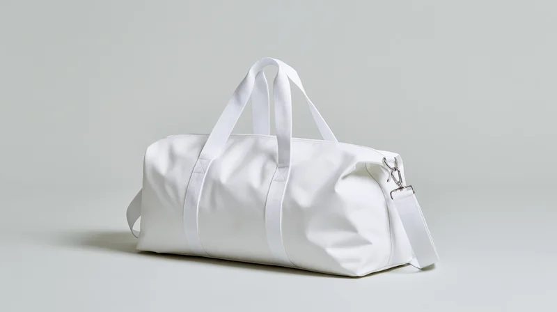 White canvas duffel bag with handles and zipper closure on plain surface