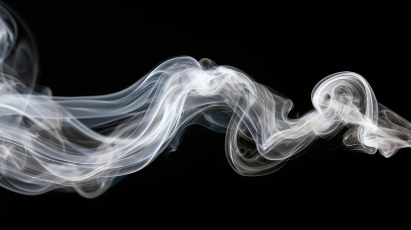 White smoke swirling in fluid wisps against a black background