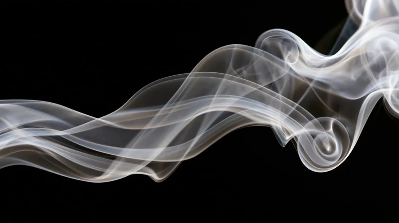 White smoke drifting in fluid curling wisps across a pure black background