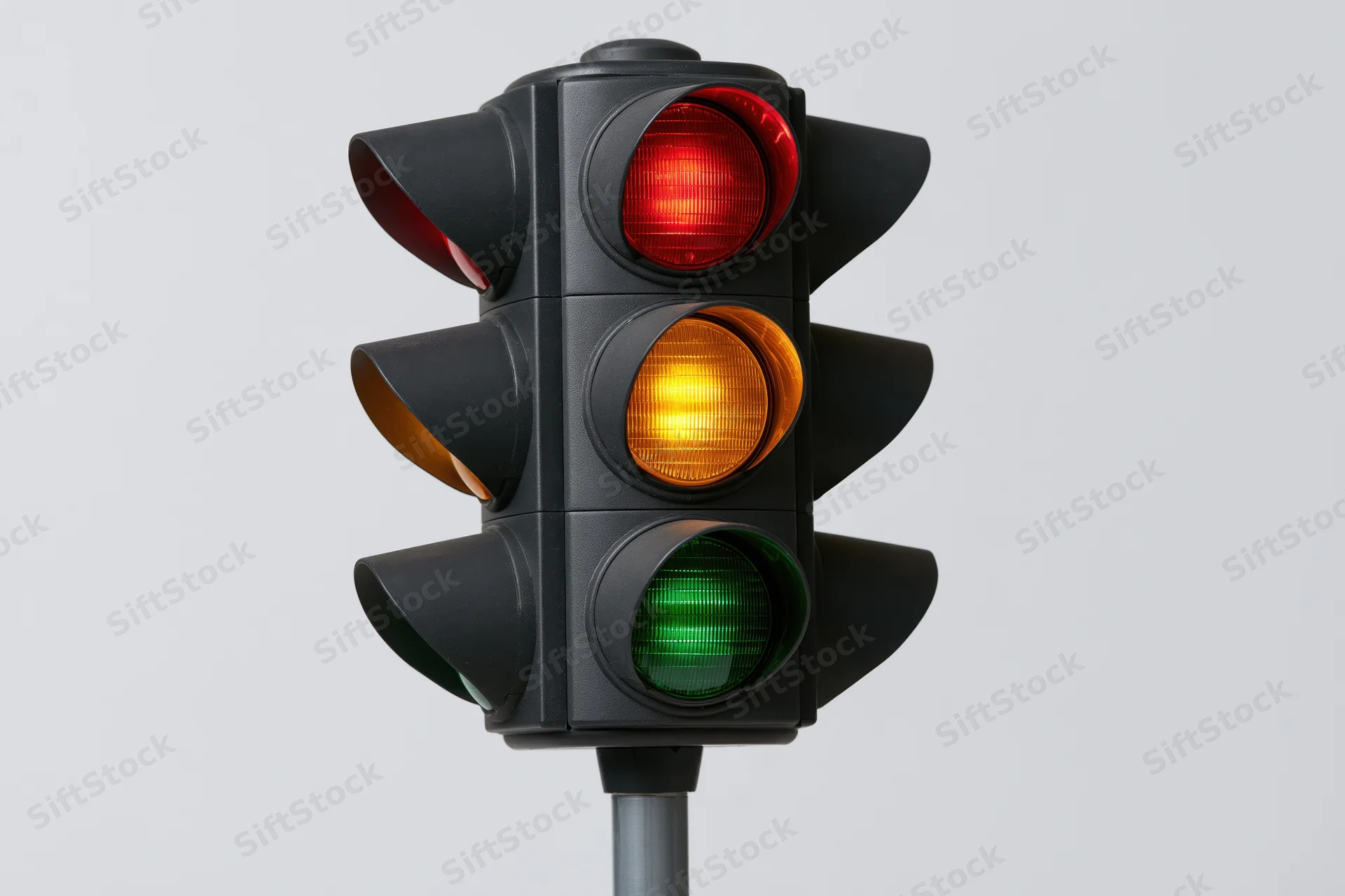 Black traffic light with all three signals illuminated on a pole against a plain background