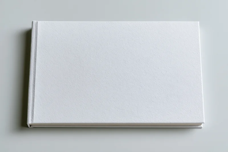 Blank white hardcover book lying flat on a plain surface in landscape orientation