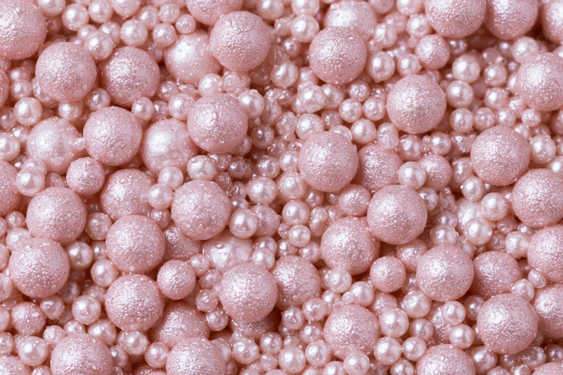 A pile of small pearlescent pink beads filling the frame